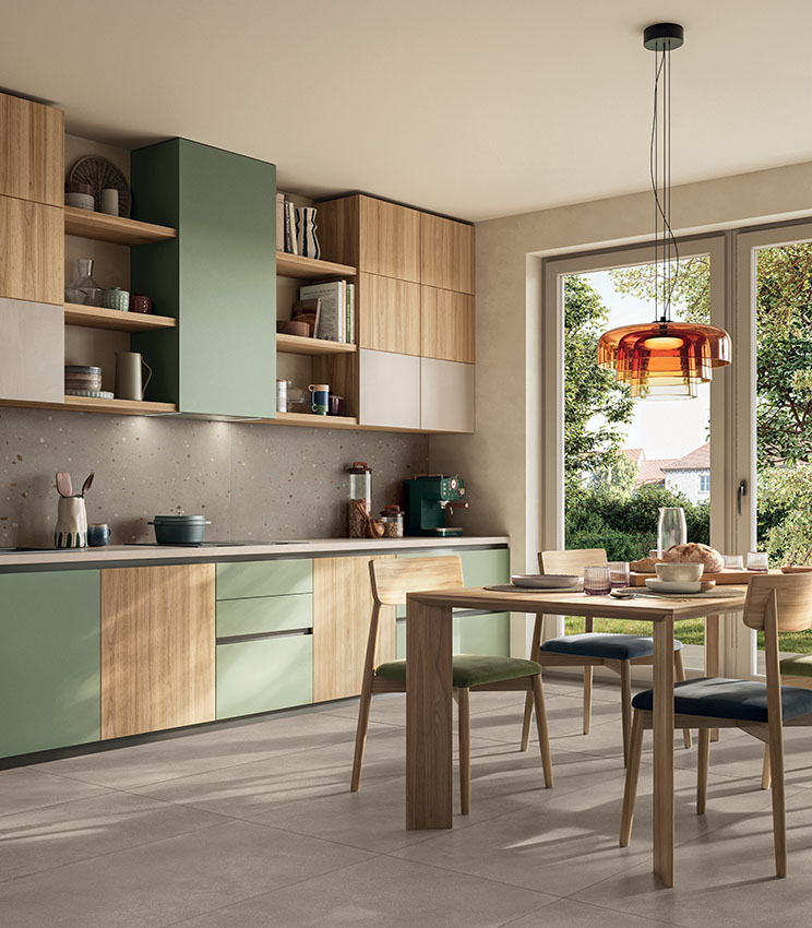 Modern and welcoming kitchen with wood and sage green cabinetry, a bright dining area and warm-toned concrete-effect porcelain stoneware flooring.
