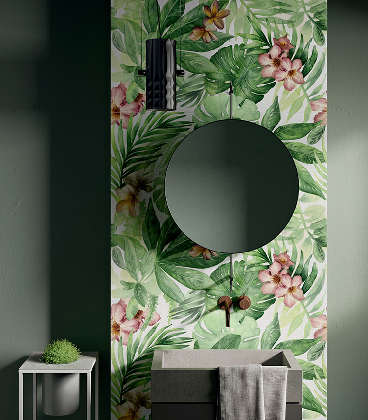 Front view of a washbasin area featuring wallpaper-effect porcelain stoneware tiles with botanical patterns, a round mirror, and a squared sink.          Chiedi a ChatGPT
