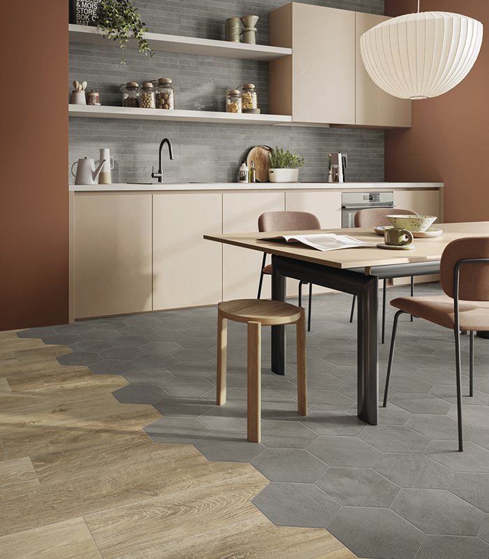 Front view of a washbasin area covered with stone-effect porcelain stoneware strips, featuring a round mirror and a red countertop sink.          Chiedi a ChatGPT