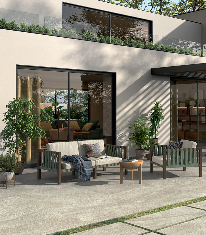 Spazio outdoor arredato con pavimentazione effetto pietra The Place di Panaria Ceramica, dall’eleganza naturale e contemporanea.