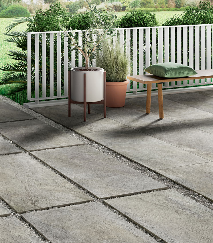 View of an outdoor porcelain stoneware flooring in stone effect, 20 mm thick, partly terrace (adhesive-laid) and partly pathway with dry-laid installation on gravel | Pierre de Rêves collection by Panaria Ceramica