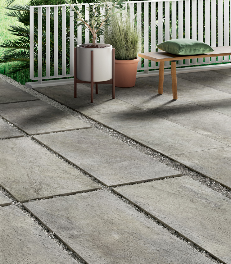 View of an outdoor porcelain stoneware flooring in stone effect, 20 mm thick, partly terrace (adhesive-laid) and partly pathway with dry-laid installation on gravel | Pierre de Rêves collection by Panaria Ceramica